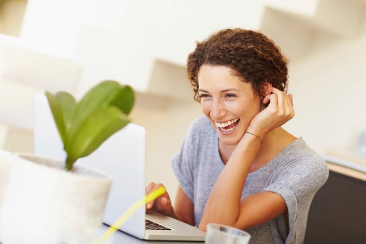 Laughing young woman checking her emails