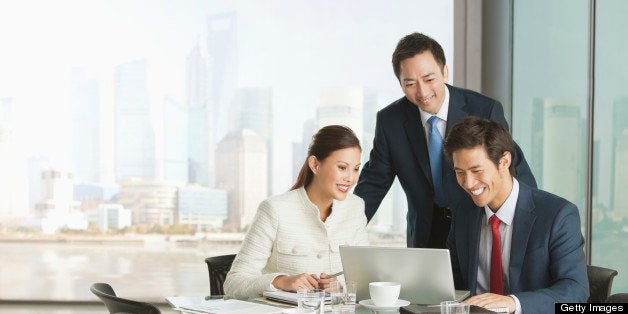 Business people using laptop in meeting