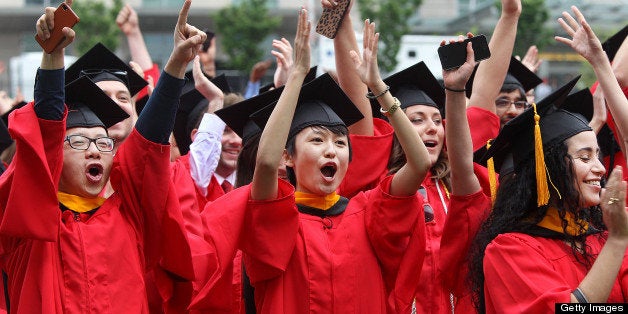 BOSTON - MAY 19: Graduates, including Tong Zhang, center, cheer during the presentation and promotion of candidates as Boston University holds its commencement ceremony on Nickerson Field, on Sunday, May 19, 2013. (Photo by Pat Greenhouse/The Boston Globe via Getty Images)