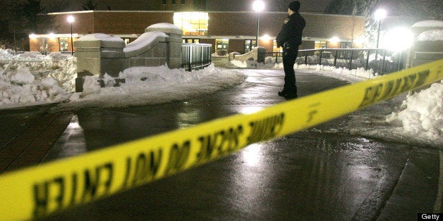 UNITED STATES - FEBRUARY 14: A police officer stands guard at his post beyond crime-scene tape outside Cole Hall on the campus of Northern Illinois University in DeKalb, Illinois, U.S. on Thursday, Feb. 14, 2008. A shotgun-wielding man opened fire on students in a classroom at Northern Illinois University's DeKalb campus before killing himself today. Four other people were killed, CNN reported. (Photo by Tim Boyle/Bloomberg via Getty Images)