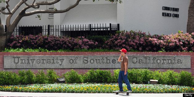 A student rides his skateboard past an entrance to the University of Southern California (USC) campus in Los Angeles on April 11, 2012 in California. Two Chinese graduate students from the university were killed early April 11 in a shooting which could have been a failed carjacking in an area southwest of downtown Los Angeles, according to police. Los Angeles has a large Chinese and Chinese-American population, including many students, and certain areas of the city are known for frequent gun violence. AFP PHOTO/Frederic J. BROWN (Photo credit should read FREDERIC J. BROWN/AFP/Getty Images)