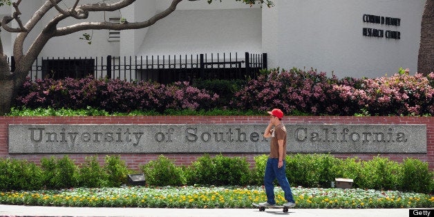 A student rides his skateboard past an entrance to the University of Southern California (USC) campus in Los Angeles on April