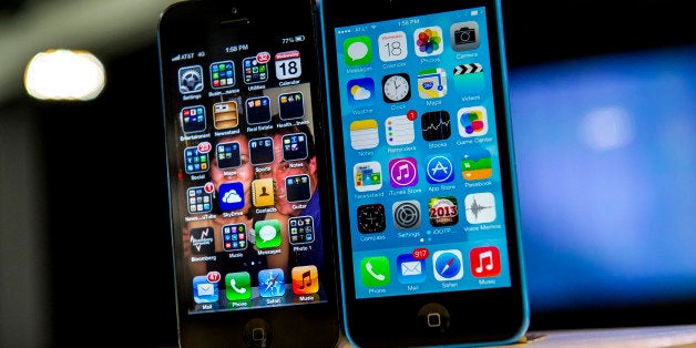 The home screen of an Apple Inc. iPhone 5 operating iOS 6, left, and an iPhone 5C operating iOS 7 is displayed in San Francisco, California, U.S., on Wednesday, Sept. 18, 2013. Buying memory to store more photos, videos and applications on a smartphone costs most consumers about $50. For Apple Inc. customers, it costs four times more than that. Photographer: David Paul Morris/Bloomberg via Getty Images