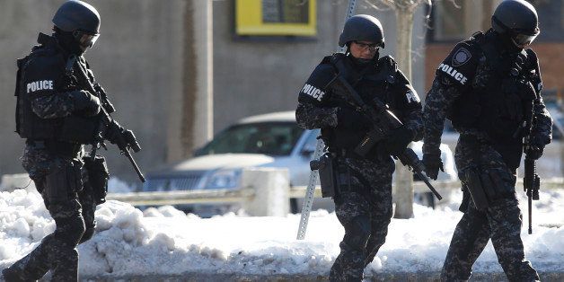 CAMBRIDGE, MA - DECEMBER 16: Members of the Cambridge Police Special Response Team walk the perimeter of Memorial Hall during a bomb scare at Harvard University in Cambridge, Massachusetts on December 16, 2013. (Photo by Jessica Rinaldi for The Boston Globe via Getty Images)