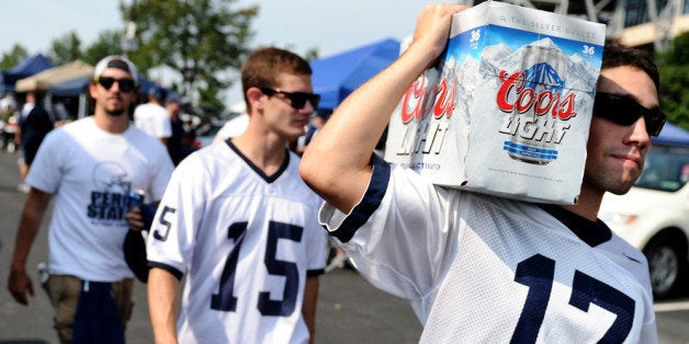 STATE COLLEGE, PA - SEPTEMBER 01: Penn State tailgaters walks with beer in the parking lot prior to the Penn State Nittany Lions playing the Ohio Bobcats at Beaver Stadium on September 1, 2012 in State College, Pennsylvania. (Photo by Patrick Smith/Getty Images)