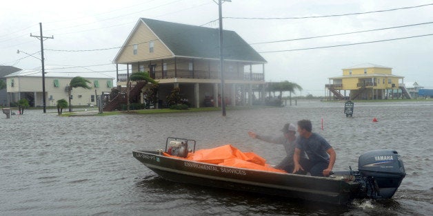 MYRTLE GROVE, LA - SEPTEMBER 3: Plaquemines Parish emergency workers rush to lay out tubes to be filled with water to heighten a levee following heavy rains from Tropical Storm Lee that hit the area September 3, 2011 in Myrtle Grove, Louisiana. The U.S. National Hurricane Center (NHC) warned of heavy rain across southeastern and south-central Louisiana and forcasted that the storm would continue its slow, potentially erratic motion toward the north or northwest over the next day. (Photo by Cheryl Gerber/Getty Images)