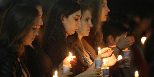 LOS ANGELES , CA - MAY 26: Students of UCSB and UCLA mourn at a candlelight vigil at UCLA for the victims of a killing rampage over the weekend near UCSB on May 26, 2014 in Los Angeles, California. According to reports, 22 year old Elliot Rodger, son of assistant director of the Hunger Games, Peter Rodger, began his mass killing near the University of California, Santa Barbara by stabbing three people to death in an apartment. He then went on to shooting and running down people while driving his BMW until crashing with a self-inflicted gunshot wound to the head. Officers found three legally-purchased guns registered to him inside the vehicle. Prior to the murders, Rodger posted YouTube videos declaring his intention to annihilate the girls who rejected him sexually and others in retaliation for his remaining a virgin at age 22. Seven people died, including Rodger, and seven others were wounded. (Photo by David McNew/Getty Images)