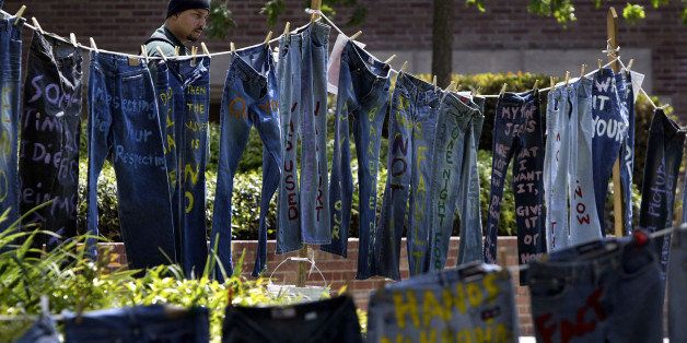 LOS ANGELES - APRIL 21: A man looks at blue jeans with messages challenging misconceptions about sexual violence, hung by the UCLA Clothesline Project, on the University of California Los Angeles campus during Denim Day April 21, 2004 in Los Angeles, California. The UCLA Clothesline Project is a student organization which works to stop gender-based violence. In 1999, wearing jeans on Denim Day during Sexual Assault Awareness Month became an international symbol of protest against rape in response to an Italian Supreme Court decision, which overturned a rape conviction because the victim wore jeans. The Italian Court justices reasoned that the victim must have helped her attacker remove her jeans because they believed that without the victim?s help, removing the jeans would be impossible. (Photo by David McNew/Getty Images)