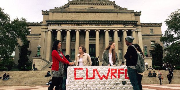 NEW YORK, NY - OCTOBER 29 : Students stand in front of the Library of the Columbia University with a mattress in support of Emma Sulkowicz's project against sexual assault, 'Carry That Weight' in which she carries her mattress around campus until her alleged rapist is expelled from the university in New York, United States on October 29, 2014. (Photo by Selcuk Acar/Anadolu Agency/Getty Images)
