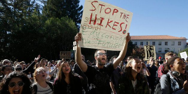 University of California Berkeley student Cameron Morgan, center, holds up a sign as he protests with students against tuition increases in Berkeley, Calif., Monday, Nov. 24, 2014. Students protesting tuition hikes in the University of California system staged walkouts at multiple campuses after the UC Board of Regents voted 14-7 to approve increases of as much as 5 percent in each of the next five years unless the state devotes more money to the system on Thursday, Nov. 20. (AP Photo/Jeff Chiu)