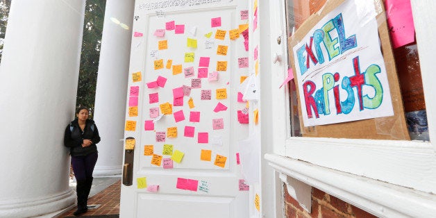 A University of Virginia student looks over postings on the door of Peabody Hall related to the Phi Kappa Psi gang rape alleg