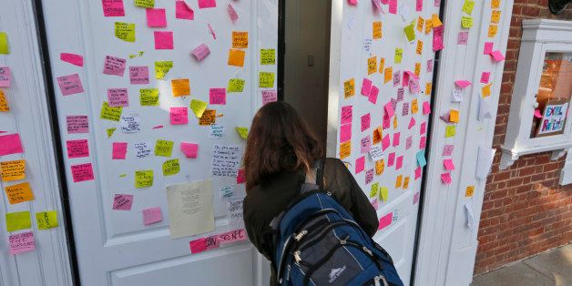 A student walks into Peabody Hall the undergraduate admissions building at the University of Virginia in Charlottesville, Va., Monday, Nov. 24, 2014. The door of the building is littered with notes relating to the recent gang rape allegations. (AP Photo/Steve Helber)
