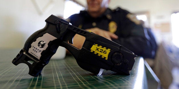 In this Nov. 14, 2013 photo, a Taser X26 is shown as Knightstown Police Chief Danny Baker talks about being shot by the weapon to raise money for his department in Knightstown, Ind. Baker is trying to raise money to lease a new car for the department by agreeing to be shot with his Taser. (AP Photo/Michael Conroy)