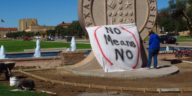 Texas Tech freshman Regan Elder helps drape a bed sheet with the message " No means No," over the university's seal on the Lubbock campus on Wednesday, Oct. 1, 2014. Students put up the bed sheets at three locations to protest what they say is a "rape culture" on campus. The women's actions came a day after university officials sent an email to students and faculty that called activities at a recent off-campus fraternity party âreprehensible.â A picture of a banner at the Sept. 20 Phi Delta Theta fraternity gathering, briefly posted online, read, âno means yes, followed by a graphic sexual remark. (AP Photo/Betsy Blaney)