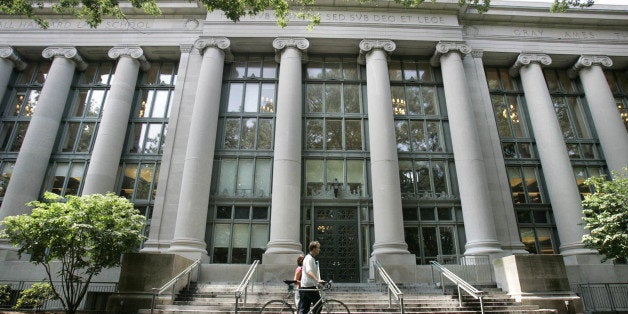 A bicyclist walks by Langdell Hall, the Harvard Law Library, on the campus of the Harvard Law School in Cambridge, Mass., Monday, Aug. 1, 2005. Black-robed for two centuries, the Supreme Court justices could be sporting a new color next term: crimson. That would be to honor Harvard Law School, which if John Roberts is confirmed, could make an unprecedented boast: five of its graduates serving on the high court simultaneously. A sixth justice, Ruth Bader Ginsberg, attended Harvard Law but finished her degree at Columbia. (AP Photo/Charles Krupa)