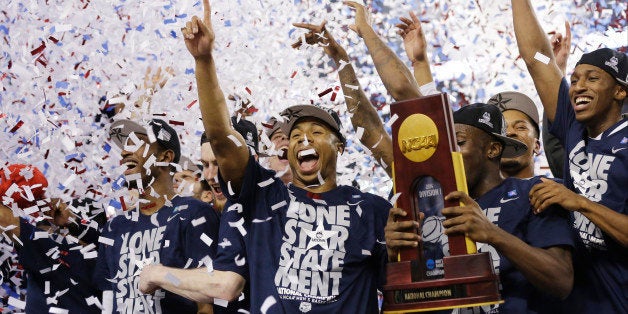 Connecticut celebrates with the championship trophy after beating Kentucky 60-54 at the NCAA Final Four tournament college basketball championship game Monday, April 7, 2014, in Arlington, Texas. (AP Photo/David J. Phillip)