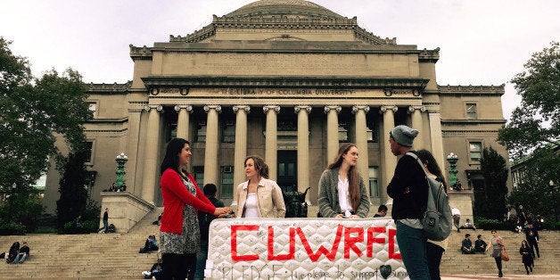 NEW YORK, NY - OCTOBER 29 : Students stand in front of the Library of the Columbia University with a mattress in support of Emma Sulkowicz's project against sexual assault, 'Carry That Weight' in which she carries her mattress around campus until her alleged rapist is expelled from the university in New York, United States on October 29, 2014. (Photo by Selcuk Acar/Anadolu Agency/Getty Images)