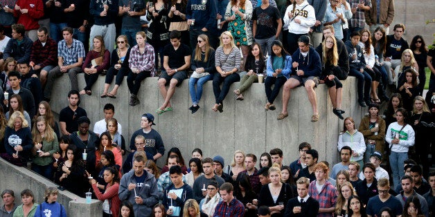 Students gather for a candlelight vigil to honor the victims of Friday night's mass shooting on Saturday, May 24, 2014, on th
