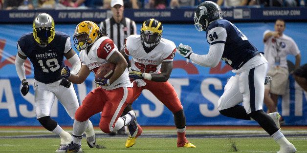 East running back Terrence Magee (15), of LSU, rushes for yardage between West linebacker Tony Washington (19), of Oregon, and linebacker Taiwan Jones (34), of Michigan State, during the first half of the East-West Shrine college football game in St. Petersburg, Fla., Saturday, Jan. 17, 2015.(AP Photo/Phelan M. Ebenhack)