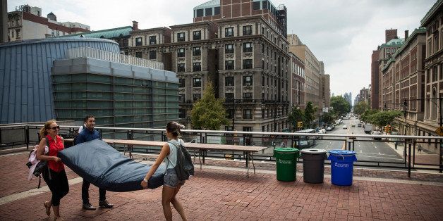 NEW YORK, NY - SEPTEMBER 05: Emma Sulkowicz (R), a senior visual arts student at Columbia University, carries a mattress, with the help of two strangers who met her moments before, in protest of the university's lack of action after she reported being raped during her sophomore year on September 5, 2014 in New York City. Sulkowicz has said she is committed to carrying the mattress everywhere she goes until the university expels the rapist or he leaves. The protest is also doubling as her senior thesis project. (Photo by Andrew Burton/Getty Images)