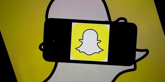 The Snapchat Inc. logo is displayed for a photograph on an Apple Inc. iPhone 5s and laptop computer in Washington, D.C., U.S., on Wednesday, Feb. 18, 2015. Snapchat Inc. is raising money that could value the company at as much as $19 billion. Photographer: Andrew Harrer/Bloomberg via Getty Images