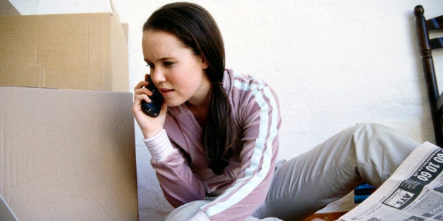 Woman multitasking with cell phone, laptop and newspaper