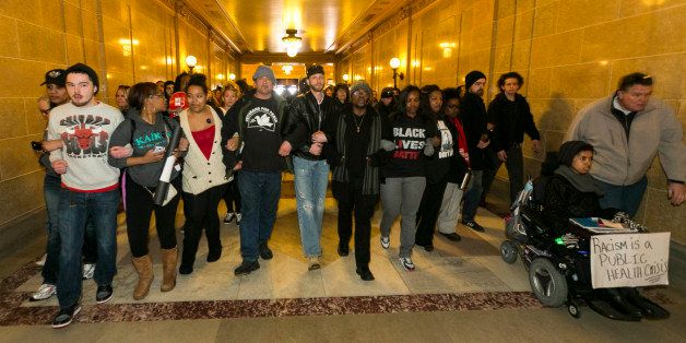 Demonstrators make their way into the state Capitol to protest the shooting of Tony Robinson, Monday, March 9, 2015, in Madison, Wis. Robinson, 19, was fatally shot Friday night by a police officer who forced his way into an apartment after hearing a disturbance while responding to a call. Police say Robinson had attacked the officer. (AP Photo/Andy Manis)