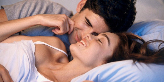 Young couple lying on a bed laughing