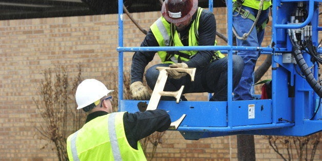 Facility workers removed the letters from the Sigma Alpha Epsilon house at the University of Oklahoma on Monday, March. 9, 2015 in Norman, Okla. University President David Boren severed the school's ties with a national fraternity on Monday and ordered that its on-campus house be shuttered after several members took part in a racist chant caught in an online video. (AP Photo/Nick Oxford)