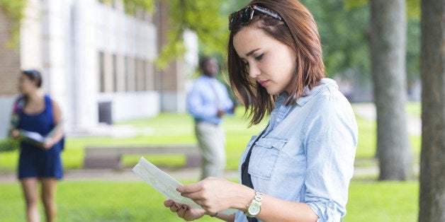 Young college student studying class schedule or campus map 