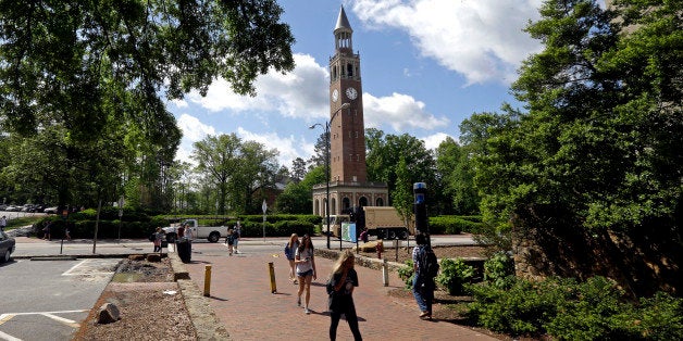 In this photo taken Monday, April 20, 2015, the Bell Tower looms over students on campus at The University of North Carolina in Chapel Hill, N.C. (AP Photo/Gerry Broome)