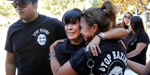 Family members of late Armando Villa, from left: Joshua Castaneda, his mother Martha Castaneda, and aunt, Maria Castaneda react as California State University, Northridge, CSUN president Dr. Dianne Harrison, not seen, reads a statement regarding Pi Kappa Phi Fraternity activities that lead to the death of CSUN student Armando Villa, during a news conference at the CSUN campus in Northridge, Calif., on Friday, Sept. 5, 2014. Villa died during a fraternity-sponsored hike in the Angeles National Forest. (AP Photo/Damian Dovarganes)