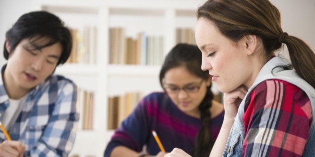 Young women and man studding in library