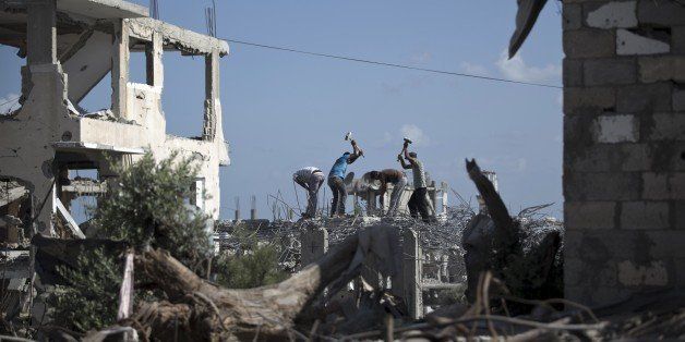 Palestinian workers remove the rubble of a building that was destroyed during the 50-day war between Israel and Hamas militants in the summer of 2014, on August 25, 2015 in Gaza City's eastern suburb of al-Shejaiya. AFP PHOTO / MOHAMMED ABED (Photo credit should read MOHAMMED ABED/AFP/Getty Images)