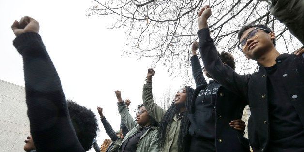Students at Boston College raise their arms during a solidarity demonstration on the school's campus, Thursday, Nov. 12, 2015, in Newton, Mass. The protest was among numerous campus actions around the country following the racially charged strife at the University of Missouri. (AP Photo/Steven Senne)