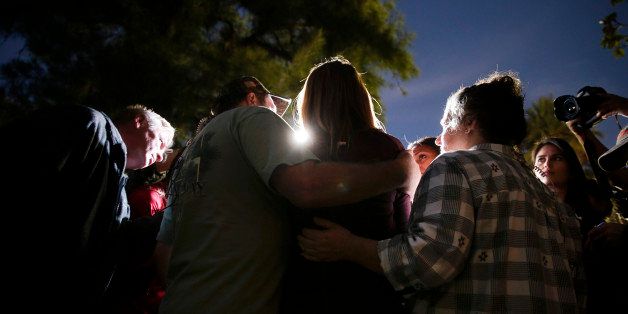 A woman, center, who survived a shooting rampage, talks to members of the media outside a community center after she reunited with her parents Wednesday, Dec. 2, 2015, in San Bernardino, Calif. Multiple attackers opened fire on a banquet at a social services center for the disabled in San Bernardino on Wednesday, killing multiple people and sending police on a manhunt for suspects. (AP Photo/Jae C. Hong)