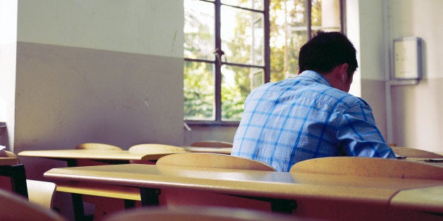 Young boy studying in classroom.