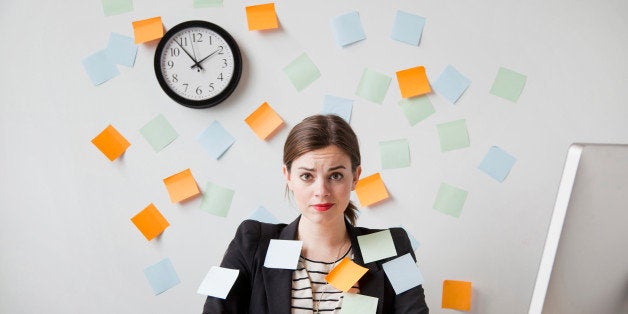 Studio shot of young woman working in office covered with adhesive notes