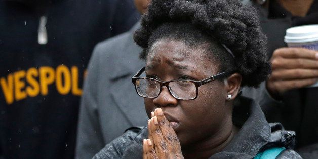 Boston College student Akosua Opokua-Achampong, of Lake Hopatcong, N.J., places her hands together during a solidarity demonstration on the school's campus, Thursday, Nov. 12, 2015, in Newton, Mass. The protest was among numerous campus actions around the country following the racially charged strife at the University of Missouri. (AP Photo/Steven Senne)