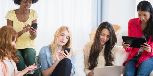 Women using technology on sofa