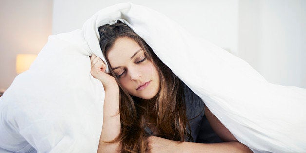 young woman looking tired in bed