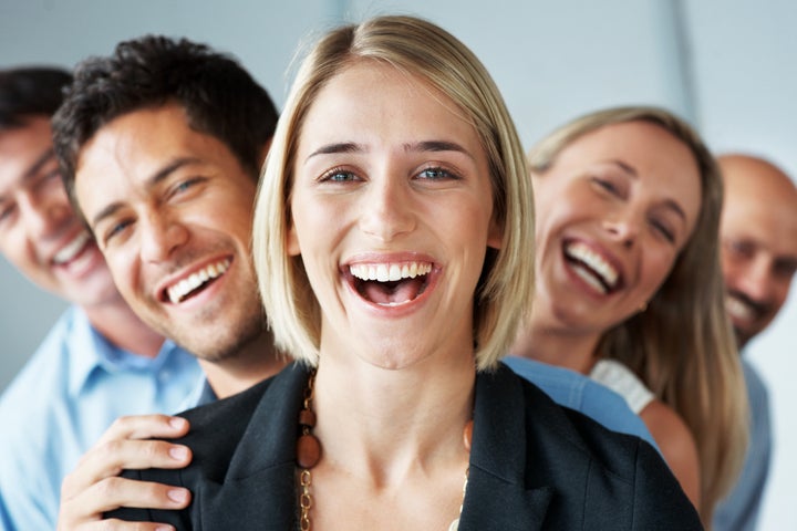 Portrait of a happy young female business leader stading in front of her team