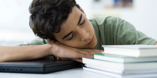 Male high school student napping at desk