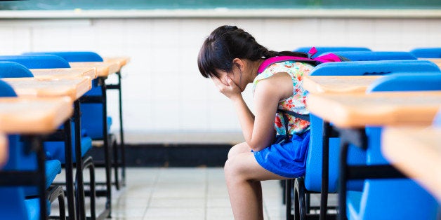 sad girl sitting and thinking in the classroom