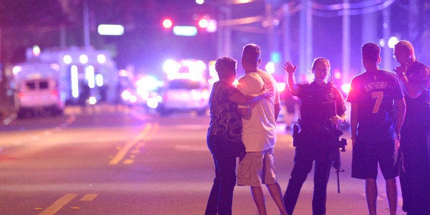 Orlando Police officers direct family members away from a fatal shooting at Pulse Orlando nightclub in Orlando, Fla., Sunday,