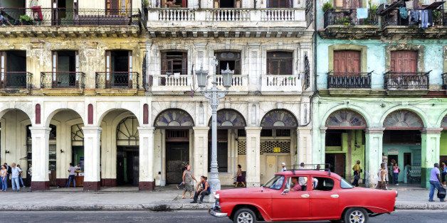 Street scene with vintage car and worn out buildings in Havana, Cuba.