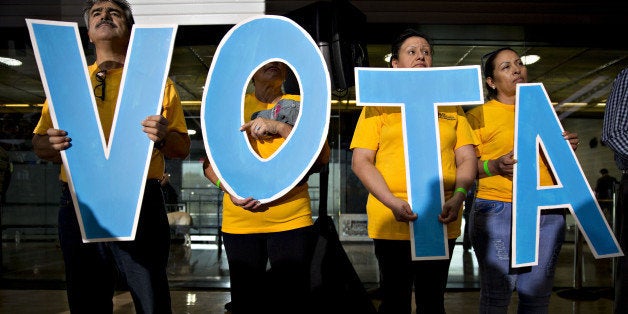 Attendees hold letters reading 'Vote' in Spanish during a campaign event with Tim Kaine, 2016 Democratic vice presidential nominee, in Phoenix, Arizona, U.S., on Thursday, Nov. 3, 2016. Five days from the U.S. presidential election, polls released Thursday showed the race narrowing, with Democrat Hillary Clinton holding on to a slim lead over Republican Donald Trump. Photographer: Daniel Acker/Bloomberg via Getty Images