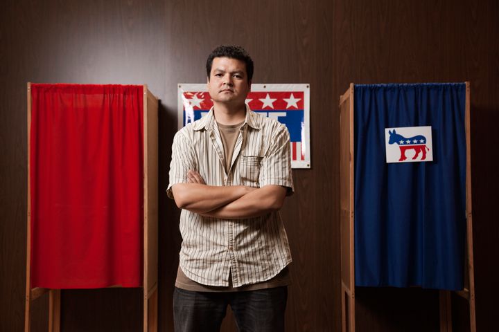 Mixed race man waiting to vote in polling place