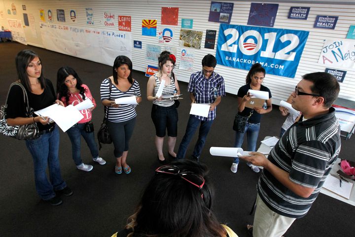 In this Friday, June 29, 2012 photo, Brian Conklin, far right, a regional campaign director for the reelection of President Barack Obama, briefs volunteers about registering new voters prior to them canvassing a heavily Latino neighborhood in Phoenix. Across the country both political parties have been courting the Latino vote, the nation's fastest-growing minority group.(AP Photo/Ross D. Franklin)