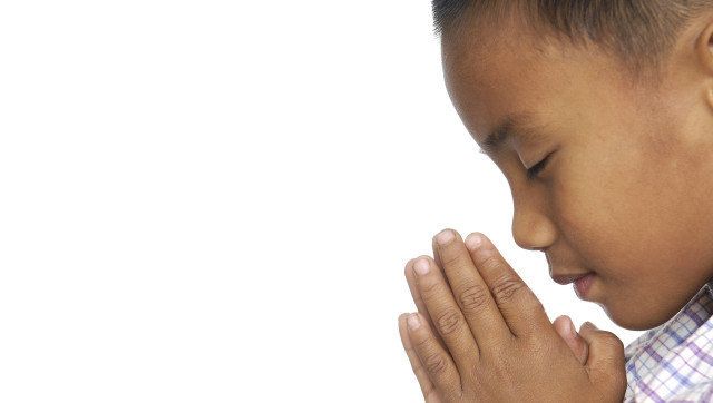 little child praying over white ...